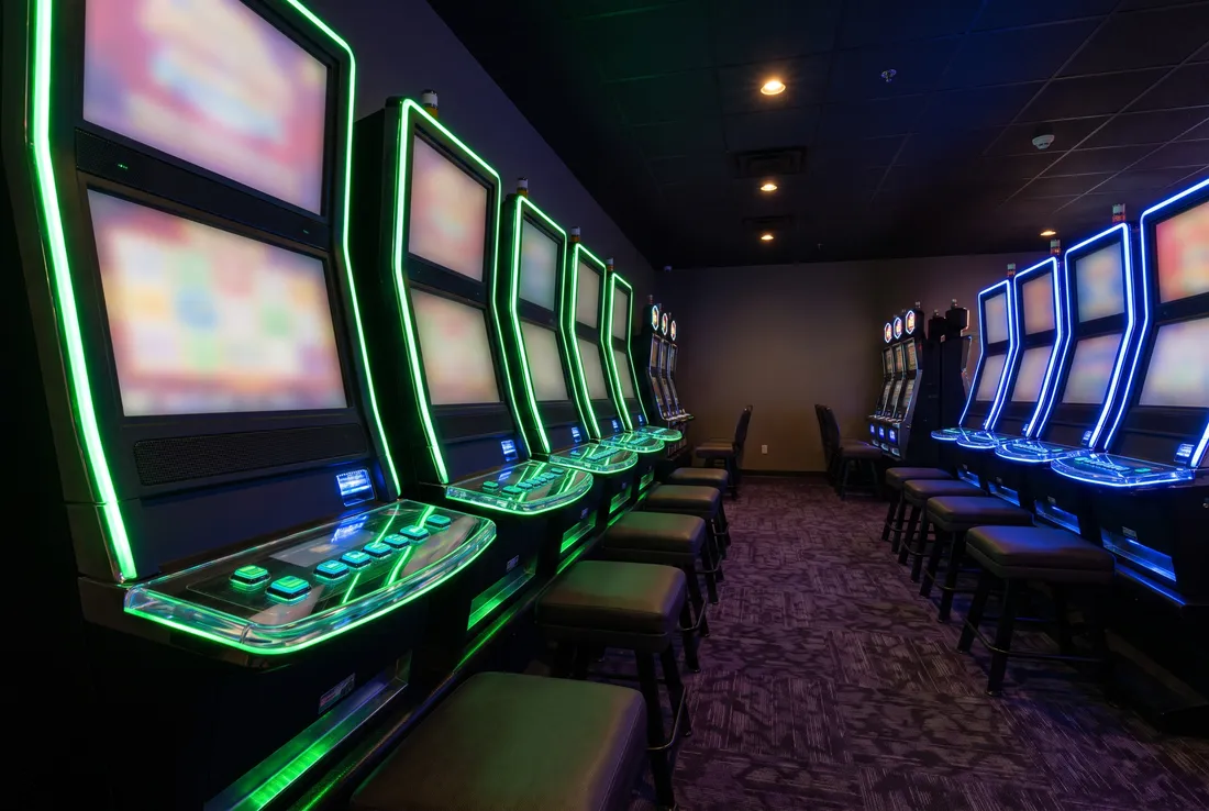 Row of green-lit slot machines at Kawartha Downs